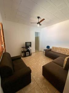 a living room with two couches and a tv at Casa das orquídeas in Santana do Riacho