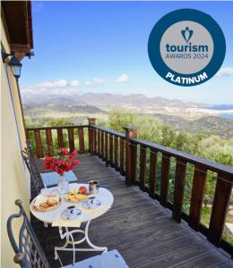 a table with food on a deck with a view at LIMNI in Agios Nikolaos
