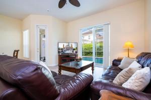 a living room with a leather couch and a table at Marvelous 4Bd Close to Disney w Pool at 313 Tuscan Hills in Davenport