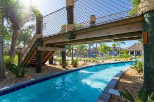 a wooden bridge over a swimming pool with a blue swimming pool at Gorgeous 4 Bedroom w Screened Pool Close to Disney 2653 in Kissimmee