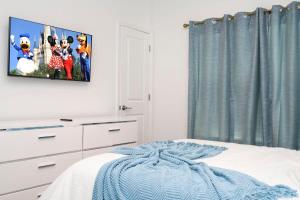 une chambre avec une télévision accrochée au mur dans l'établissement Marvelous 4Bd w Pool Close to Disney at Storey Lake 2629, à Kissimmee