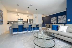 uma sala de estar com um sofá e uma mesa em Fantastic 4 Bd w Pool at Storey Lake Resort 2709 em Kissimmee