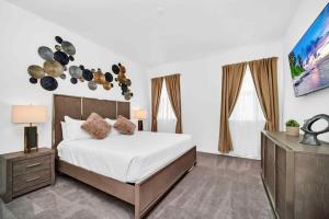 - une chambre avec un grand lit et une télévision dans l'établissement Stunning 12Bd Sleeps 25 w Pool Close to Disney at Veranda Palms 4405, à Kissimmee