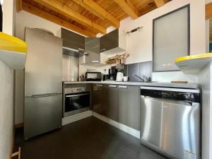 a kitchen with stainless steel appliances and wooden ceilings at Gîte Polignac, 3 pièces, 4 personnes - FR-1-582-58 in Polignac