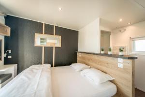 a bedroom with a large white bed in a room at Holiday Village Knokke in Knokke-Heist