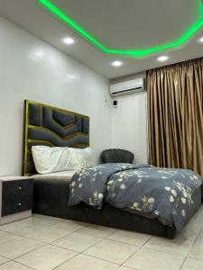 uma cama num quarto com tecto verde em Frontline em Lagos