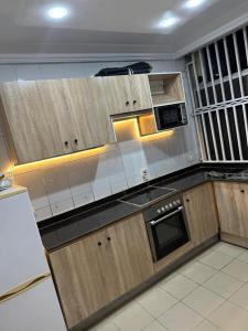 uma cozinha com armários de madeira e um forno com placa de fogão em Frontline em Lagos