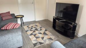 a living room with a couch and a flat screen tv at Contractor's Haven- 4-Bedroom House with Free Parking, Super Fast WiFi, Fran Properties in Aylesbury, Pets are Welcome in Buckinghamshire