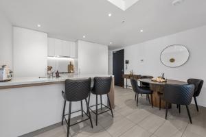 een keuken en eetkamer met een tafel en stoelen bij Chic 2-Bed with Skyline Views Pool and Gym in Brisbane