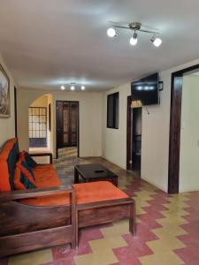 ein Wohnzimmer mit einem Bett und einem Tisch in der Unterkunft El Rinconcito de la Antigua in Antigua Guatemala