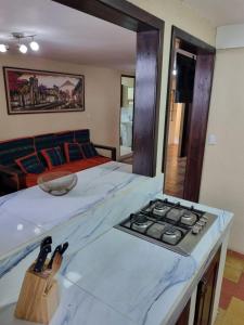 a room with a bed and a counter with a stove at El Rinconcito de la Antigua in Antigua Guatemala