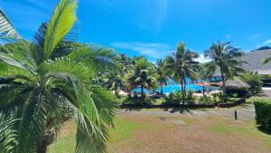 - une vue sur un complexe avec des palmiers et une piscine dans l'établissement TAHITI - Condo Lafayette Beach, à Arue