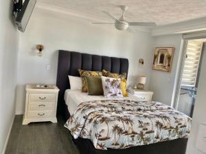 1 dormitorio con 1 cama y ventilador de techo en Wharf Boutique Apartments, en Gold Coast