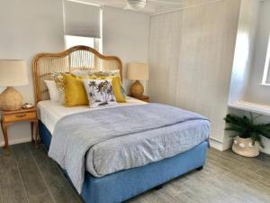 1 dormitorio con 1 cama grande con almohadas amarillas en Wharf Boutique Apartments, en Gold Coast