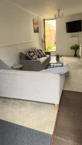 a living room with a couch and a table at Contractor's Bliss- 5-Bedroom House with Free Parking for 7 Guests, Super Fast Wifi- Fran Properties in Aylesbury
