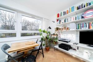 a room with a desk and a table and bookshelves at Cozy 1 bedroom flat at Earlsferry Way in London