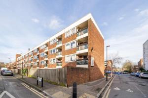 a brick apartment building on a city street at Cozy 1 bedroom flat at Earlsferry Way in London