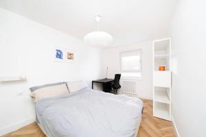 a white bedroom with a bed and a desk at Cozy double bedroom at Earlsferry Way in London