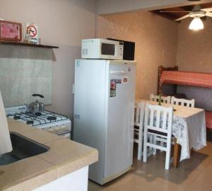 a kitchen with a microwave on top of a refrigerator at Bungalows Spa La Delfina in Gualeguaychú