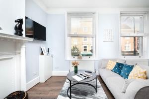 un soggiorno bianco con divano e tavolo di Cozy 1 bedroom flat in Greater London a Londra