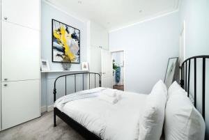 a bedroom with a black bed with white pillows at Cozy 1 bedroom flat in Greater London in London