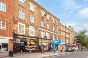 a brick building on a city street with a store at Cozy 1 bedroom flat in Greater London in London