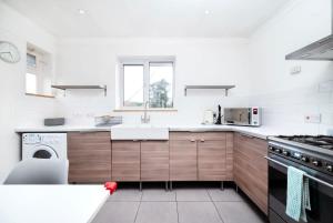 uma cozinha com um lavatório e um fogão em Delightful 3BR family house em Thames Ditton