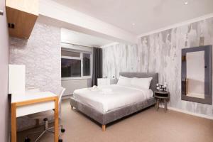 una camera con un grande letto bianco e una scrivania di Delightful 3BR family house a Thames Ditton