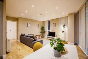 a living room with a couch and a television at Modern 2BR London Flat Style and Comfort Combined in London