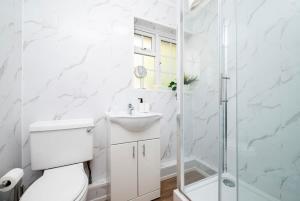 a bathroom with a toilet and a sink and a shower at Stylish 2BR Oasis Steps from Wembley Stadium in London