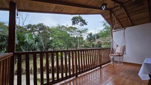 Habitación con balcón y columpio. en Hostería Finca El Pigual, en Puyo