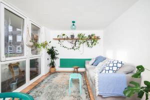 een woonkamer met een bank en een kruk bij Cozy 1-Bedroom Oasis with Balcony in London's Heart in Londen