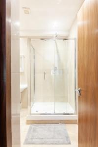 baño con ducha y puerta de cristal en Modern and comfortable air-conditioned 2BR flat, en Londres