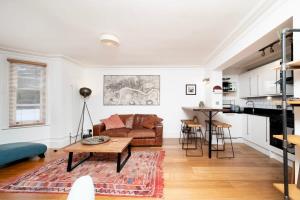 ein Wohnzimmer mit einem Sofa und einem Tisch in der Unterkunft Charming 2BR Home with Garden in Twickenham