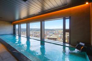 a large swimming pool with a view of a city at Ooedo Onsen Monogatari Premium Yamashitaya in Kaga