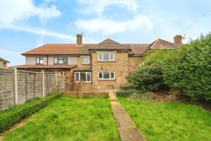 a brick house with a yard in front of it at Charming 3BR House With Free Parking and Garden in Hounslow
