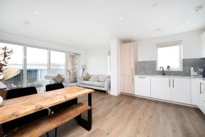 a kitchen and living room with a wooden table at Chic 2BR Flat in Greater London in London