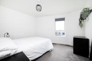 سرير أو أسرّة في غرفة في Chic 2BR Flat in Greater London