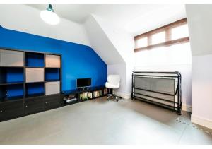 um quarto com uma parede azul e uma cama e uma cadeira em Chic Croydon 2BR Flat - Free Parking em Purley