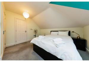 a bedroom with a large bed with two towels on it at Chic Croydon 2BR Flat - Free Parking in Purley