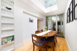 a dining room with a table and chairs and a skylight at Central London 2BR Flat with Garden in London