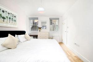 a white bedroom with a large white bed at Central London 2BR Flat with Garden in London