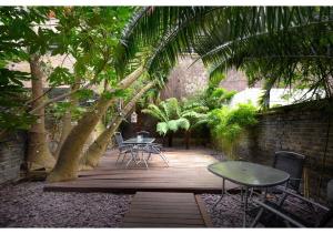 a patio with a table and chairs and trees at Central London 2BR Flat with Garden in London