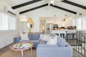 a living room with a blue couch and a kitchen at Surfrider II by AvantStay Walk to the Beach Balcony in Newport Beach