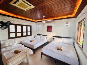 a bedroom with two beds and a wooden ceiling at Seaview Mini Chalet by StayCo - DIRECT BEACH ACCESS in Tanjung Bungah
