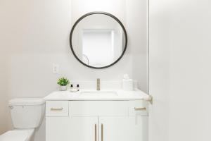 uma casa de banho branca com um lavatório e um espelho em Outrider 111 by AvantStay 5 Minutes to Broadway em Nashville