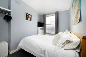 a bedroom with a white bed and a window at Chic and comfortable London 2BR home in London