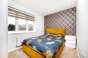 a bedroom with a yellow bed and a window at Chic and Spacious 3BR Family Home with Garden in Northolt