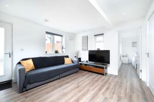 un soggiorno con divano e TV a schermo piatto di Cozy single level flat with parking a Enfield