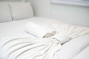 a white bed with white sheets and pillows at Cozy single level flat with parking in Enfield